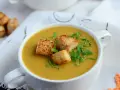 Aksamitna zupa z soczewicy z mlekiem kokosowym, udekorowana grzankami i świeżą natką pietruszki. Idealna na chłodne dni.