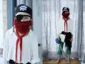 Dziecko w stroju pirata: czarna bandama z czaszką, opaska na oko, czerwona broda z włóczki, biała koszula, zielone spodnie. Jak zrobić strój pirata samemu.