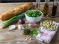 Składniki na pyszne pesto z bobu: świeży bób, bazylia, orzeszki piniowe, czosnek, oliwa, bagietka i rukola.