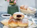 Puszyste bułeczki drożdżowe z dżemem, posypane cukrem pudrem, kuszą swoim wyglądem.