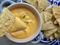 Chrupiące nachos zanurzane w kremowym sosie z serka topionego. Idealna przekąska na imprezę.