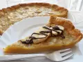 Pyszna tarta z bananami, udekorowana czekoladą i plasterkami banana, czeka na talerzu.