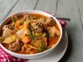Aromaticzna zupa gołąbkowa z klopsikami, kapustą i marchewką, posypana natką pietruszki.