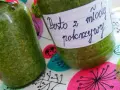 Dwa słoiki domowego pesto z młodej pokrzywy, gotowe do spożycia.