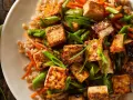 Pyszne tofu na obiad z ryżem, szparagami i marchewką. Danie wygląda apetycznie i zdrowo.
