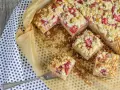 Pyszne ciasto z rabarbarem i budyniem, posypane kruszonką, pokrojone na kwadraty. Idealne na letnie popołudnie.