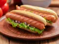Dwa apetyczne hot dogi z grillowanymi parówkami, sałatą i cebulką. Zastanawiasz się, czy można mrozić parówki? Tak, można je mrozić!