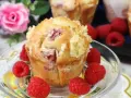 Pyszne muffinki z malinami, posypane kruszonką, otoczone świeżymi malinami. Idealne na deser.