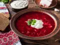 Pyszny botwinka przepis: gorący barszcz z buraków z kleksem śmietany, podany z chlebem i smalcem.