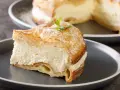 Pyszna karpatka przepis na kremowe ciasto z bitą śmietaną i ciastem parzonym, posypana cukrem pudrem.