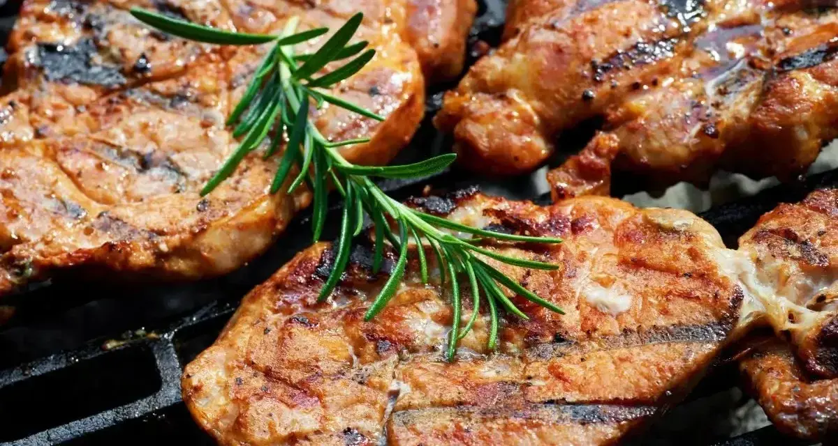 Soczysta karkówka na grillu, idealnie przyprawiona, z gałązką rozmarynu. Doskonały pomysł na to, jak przyprawić karkówkę na grilla.