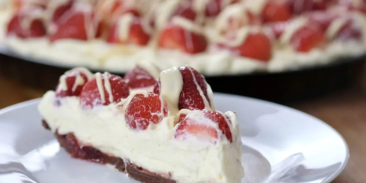 Pyszna tarta z truskawkami i mascarpone, udekorowana białym lukrem. Idealna na letnie popołudnie.
