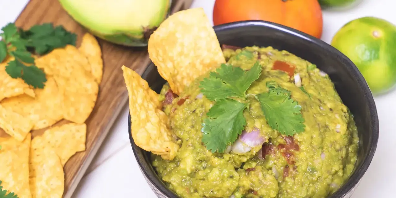 Pyszne guacamole przepis na domową przekąskę. Awokado, pomidor, limonka i kolendra tworzą idealną kompozycję.