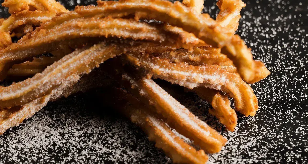 Złociste churros posypane cukrem, idealne na słodką przekąskę. Prosty churros przepis dla każdego.