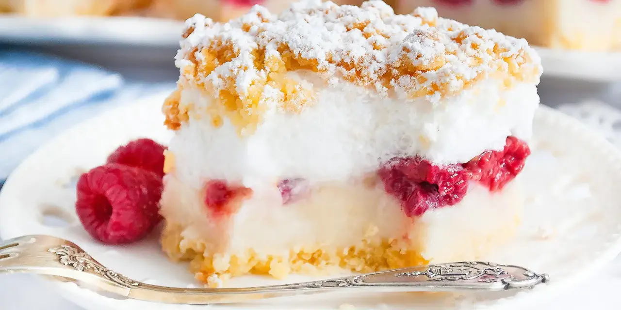 Pyszne ciasto z malinami i budyniem, posypane cukrem pudrem i kruszonką. Idealne na deser.