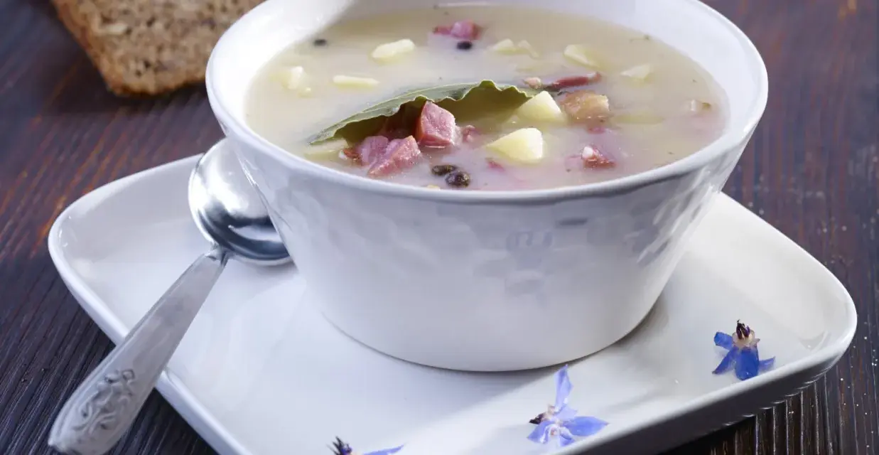 Zalewajka przepis: sycąca zupa z ziemniakami, wędzonką i liściem laurowym, podana z chlebem.