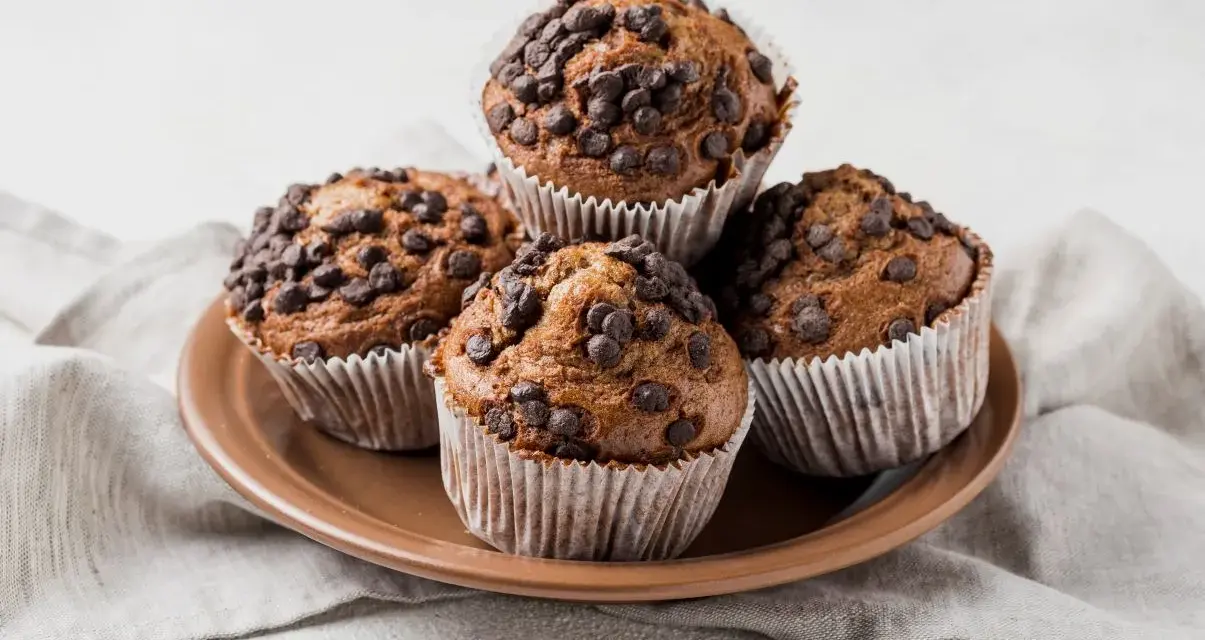 Cztery czekoladowe muffinki w papierowych foremkach, idealne do pieczenia.