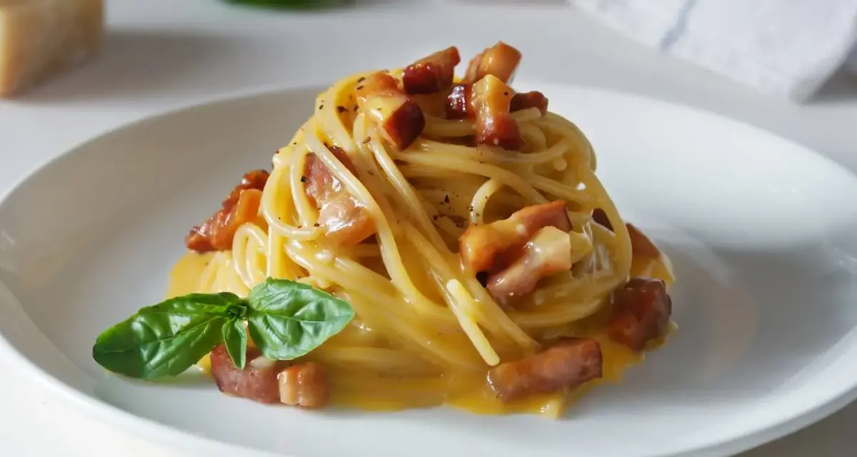 Pyszna carbonara z chrupiącym boczkiem i bazylią. Jaki ser do carbonary? Najlepszy jest parmezan lub pecorino romano.