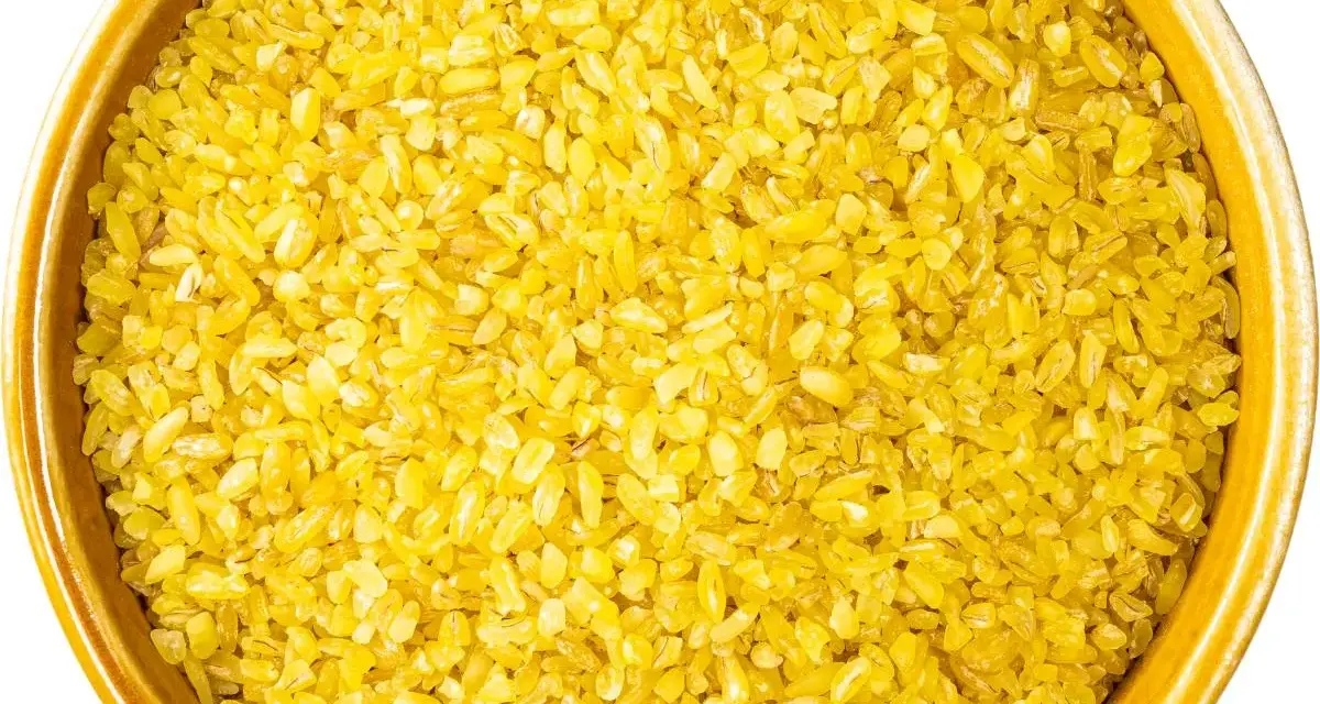 Żółta kasza bulgur w ceramicznej misce, gotowa do gotowania. Idealna baza do zdrowych dań.