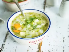 Aromaticzna zupa koperkowa z ziemniakami i marchewką, udekorowana świeżym koperkiem, podana w miseczce z napisem "Cottage".