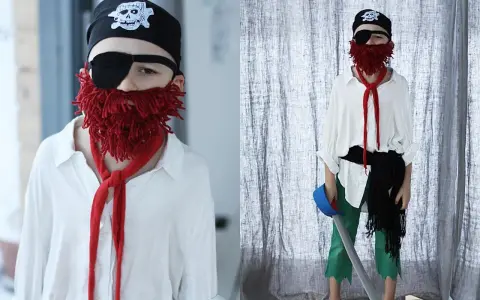 Dziecko w stroju pirata: czarna bandama z czaszką, opaska na oko, czerwona broda z włóczki, biała koszula, zielone spodnie. Jak zrobić strój pirata samemu.