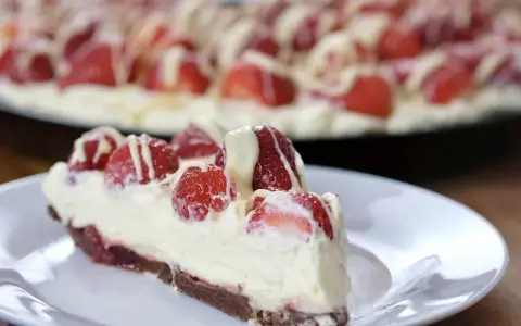 Pyszna tarta z truskawkami i mascarpone, udekorowana białym lukrem. Idealna na letnie popołudnie.