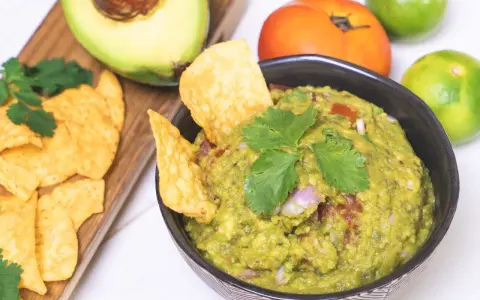 Pyszne guacamole przepis na domową przekąskę. Awokado, pomidor, limonka i kolendra tworzą idealną kompozycję.