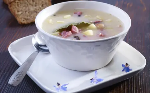 Zalewajka przepis: sycąca zupa z ziemniakami, wędzonką i liściem laurowym, podana z chlebem.