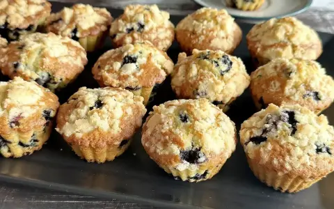 Pyszne muffinki z borówkami, posypane kruszonką, kuszą swoim wyglądem i zapachem. Idealne na deser lub śniadanie.