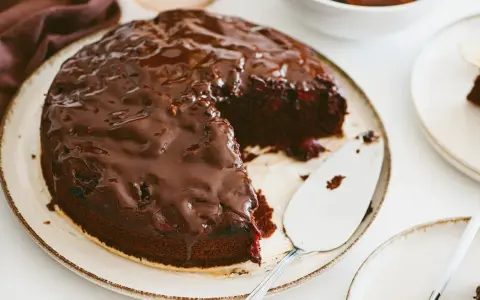 Pyszny brownie z malinami, polane błyszczącą czekoladą. Idealny deser na każdą okazję.
