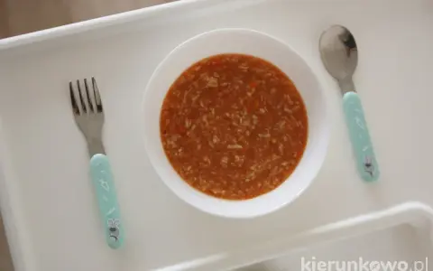 Aksamitna zupa pomidorowa dla dzieci, gotowa do jedzenia. Obok czeka widelec i łyżeczka z uroczymi króliczkami.
