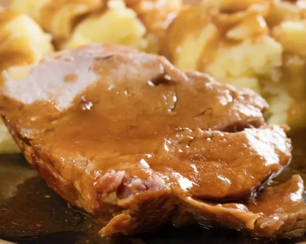 Soczysta karkówka w sosie własnym, podana z purée ziemniaczanym. Idealny obiad dla całej rodziny.