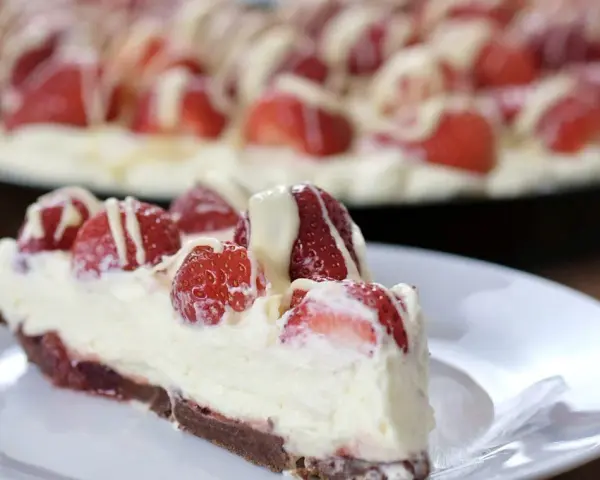 Pyszna tarta z truskawkami i mascarpone, udekorowana białym lukrem. Idealna na letnie popołudnie.