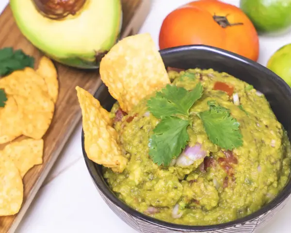 Pyszne guacamole przepis na domową przekąskę. Awokado, pomidor, limonka i kolendra tworzą idealną kompozycję.