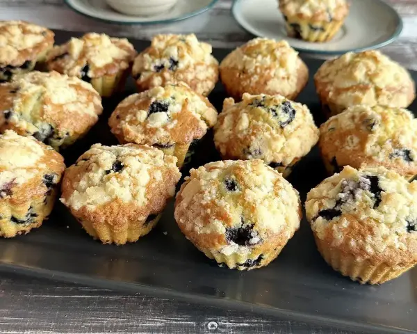 Pyszne muffinki z borówkami, posypane kruszonką, kuszą swoim wyglądem i zapachem. Idealne na deser lub śniadanie.