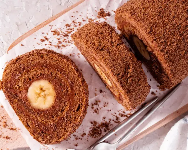 Pyszna rolada biszkoptowa z bananem w środku, posypana kakaową posypką. Idealna na deser.