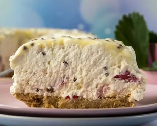 Pyszne ciasto bez pieczenia z kawałkami owoców i kremową masą. Idealne na letnie popołudnie.