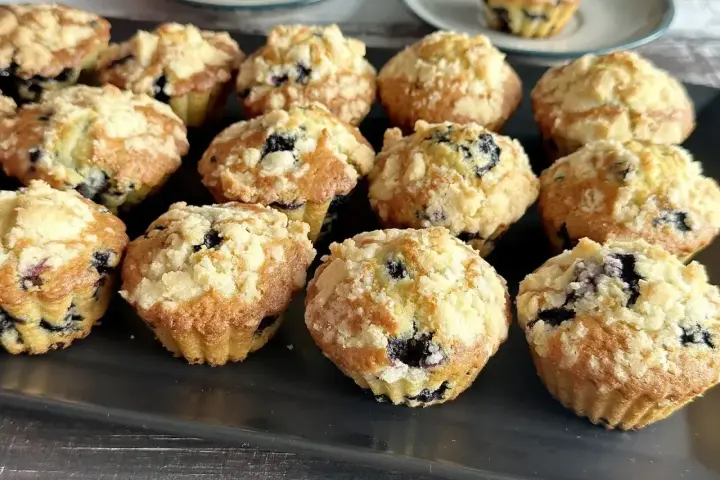 Pyszne muffinki z borówkami, posypane kruszonką, kuszą swoim wyglądem i zapachem. Idealne na deser lub śniadanie.