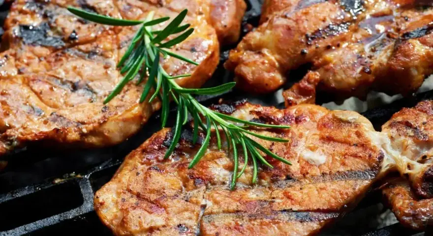 Soczysta karkówka na grillu, idealnie przyprawiona, z gałązką rozmarynu. Doskonały pomysł na to, jak przyprawić karkówkę na grilla.