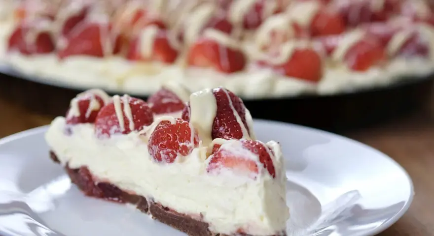 Pyszna tarta z truskawkami i mascarpone, udekorowana białym lukrem. Idealna na letnie popołudnie.