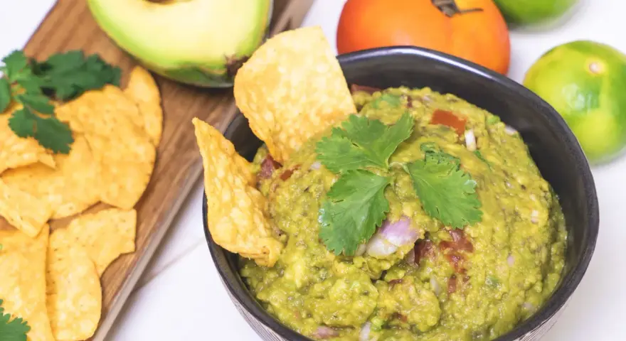 Pyszne guacamole przepis na domową przekąskę. Awokado, pomidor, limonka i kolendra tworzą idealną kompozycję.