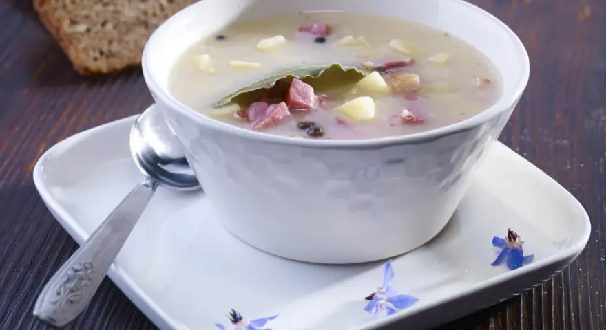 Zalewajka przepis: sycąca zupa z ziemniakami, wędzonką i liściem laurowym, podana z chlebem.