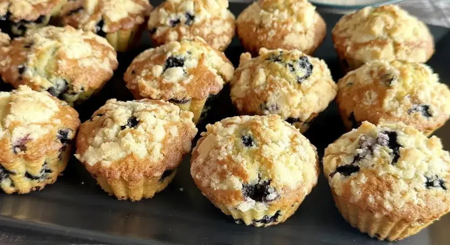 Pyszne muffinki z borówkami, posypane kruszonką, kuszą swoim wyglądem i zapachem. Idealne na deser lub śniadanie.