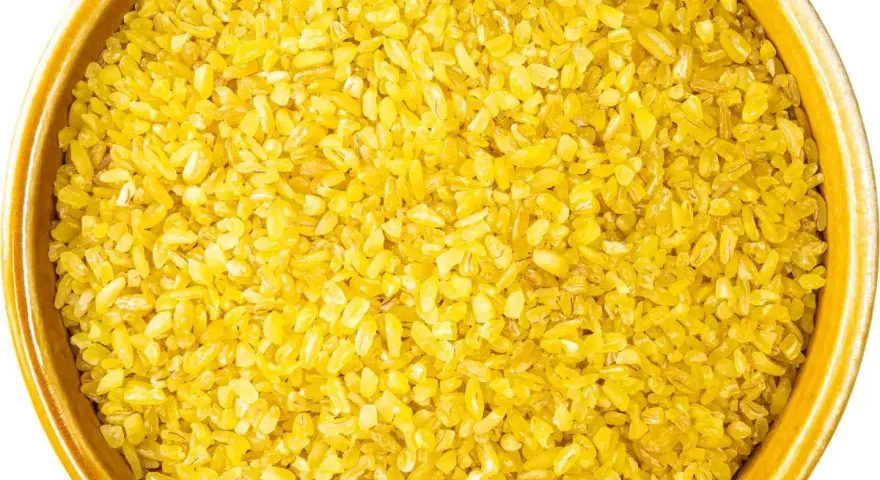 Żółta kasza bulgur w ceramicznej misce, gotowa do gotowania. Idealna baza do zdrowych dań.