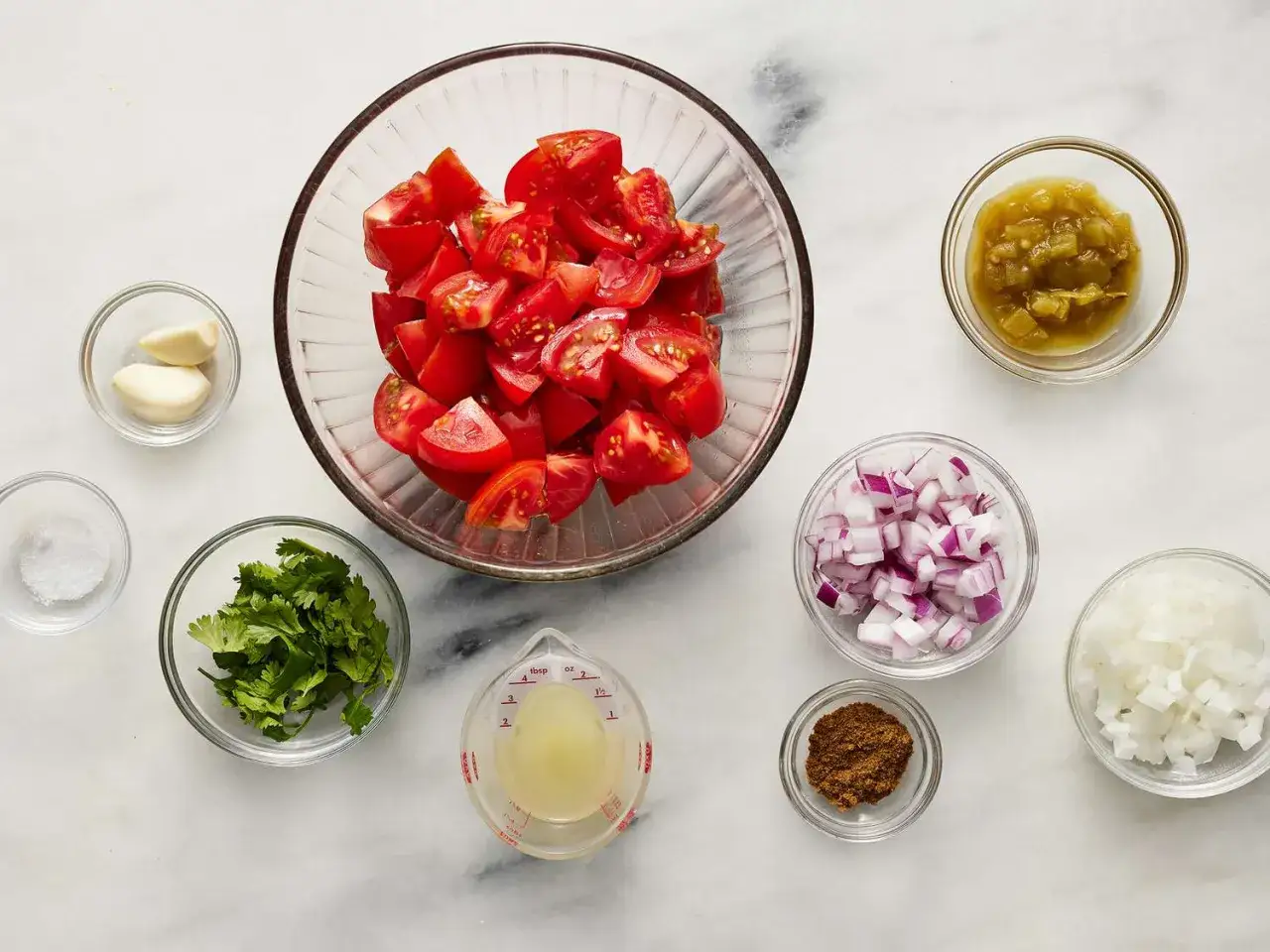 Składniki na świeże pico de gallo: pomidory, cebula, kolendra, czosnek, limonka, przyprawy.