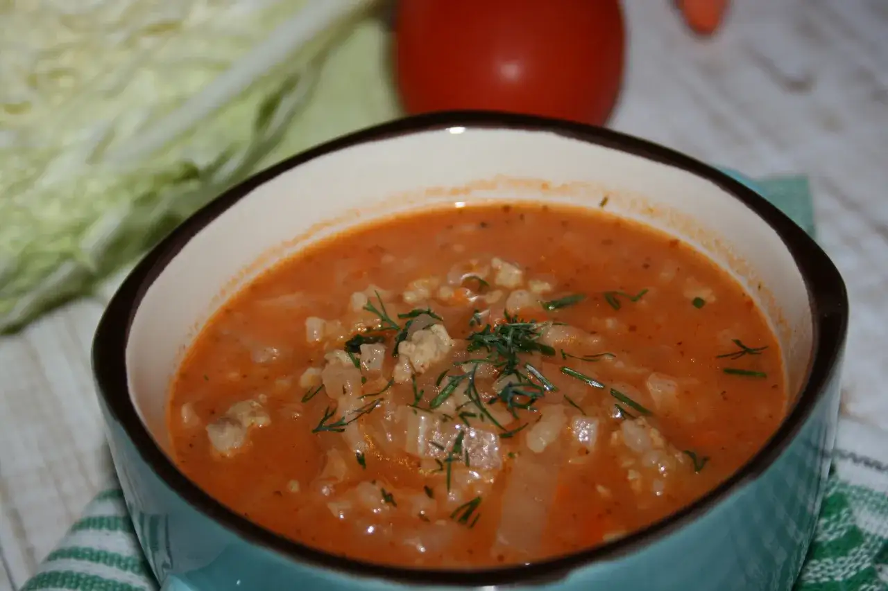 Aromaticzna zupa gołąbkowa z mielonym mięsem i kapustą, udekorowana świeżym koperkiem.