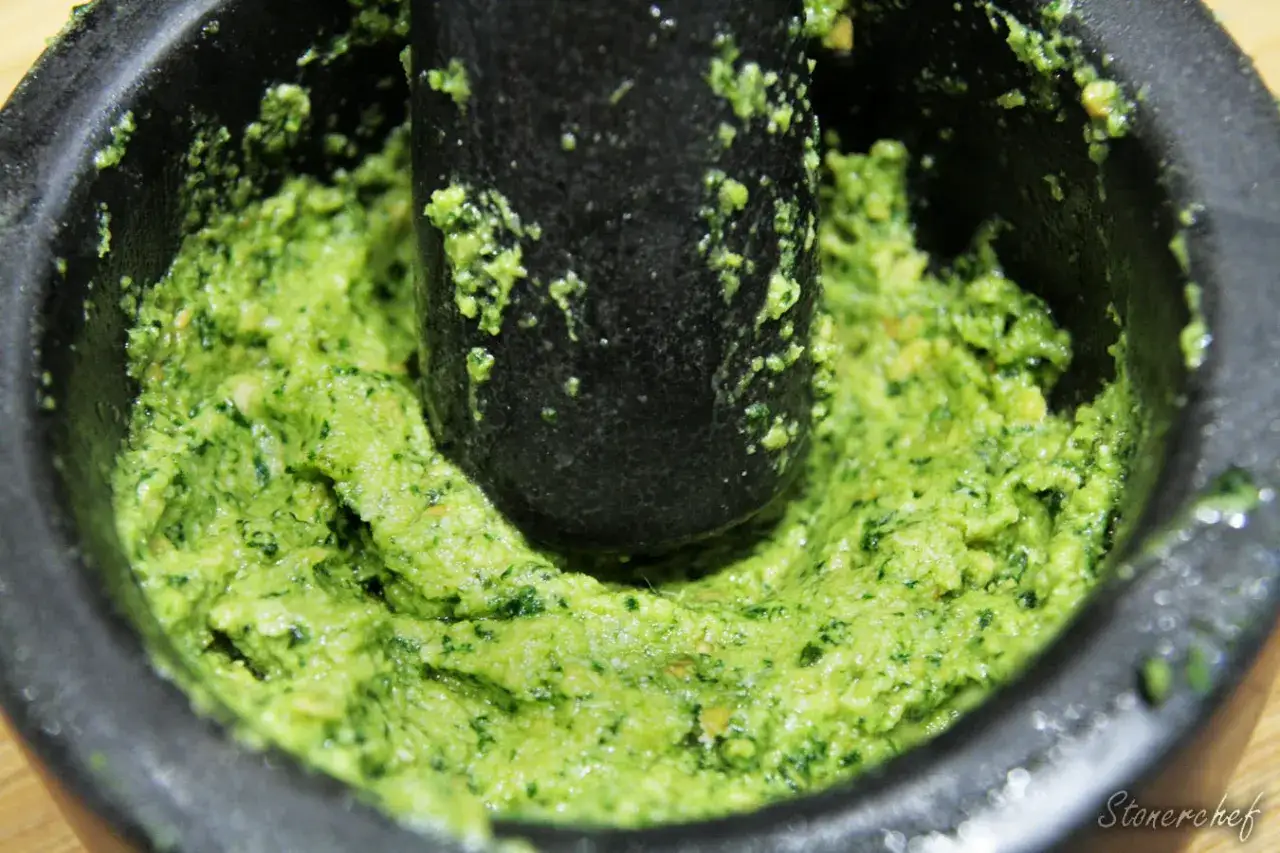 Świeżo utarte w moździerzu pesto bazyliowe, zielone i aromatyczne, gotowe do podania.