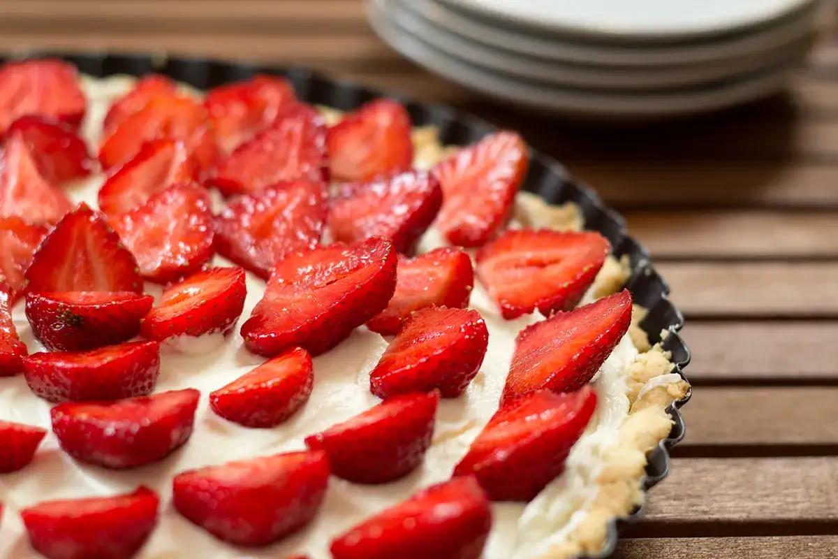 Pyszna tarta z truskawkami i mascarpone, udekorowana świeżymi owocami, czeka na spróbowanie.