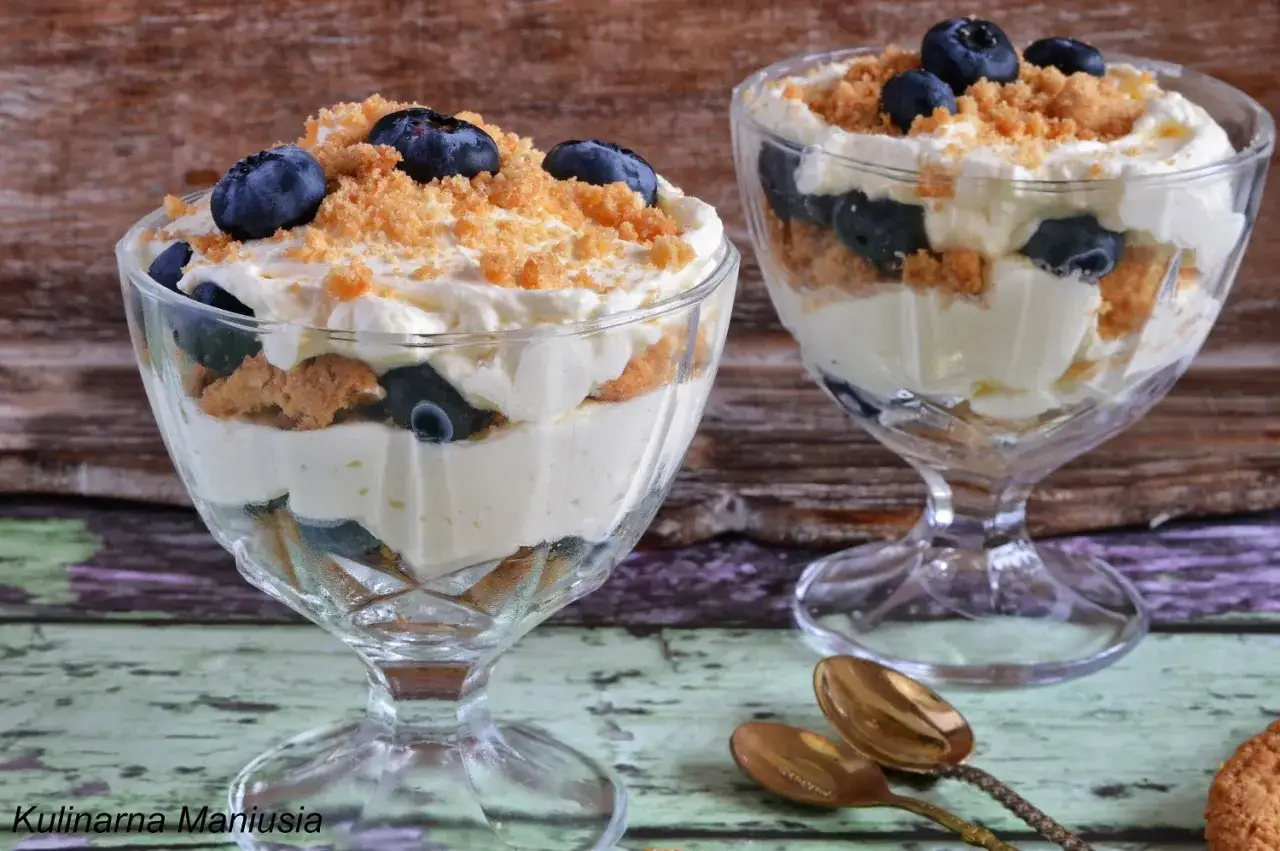 Pyszny deser z mascarpone, przełożony biszkoptami i jagodami, posypany kruszonką. Idealny na letnie popołudnie.