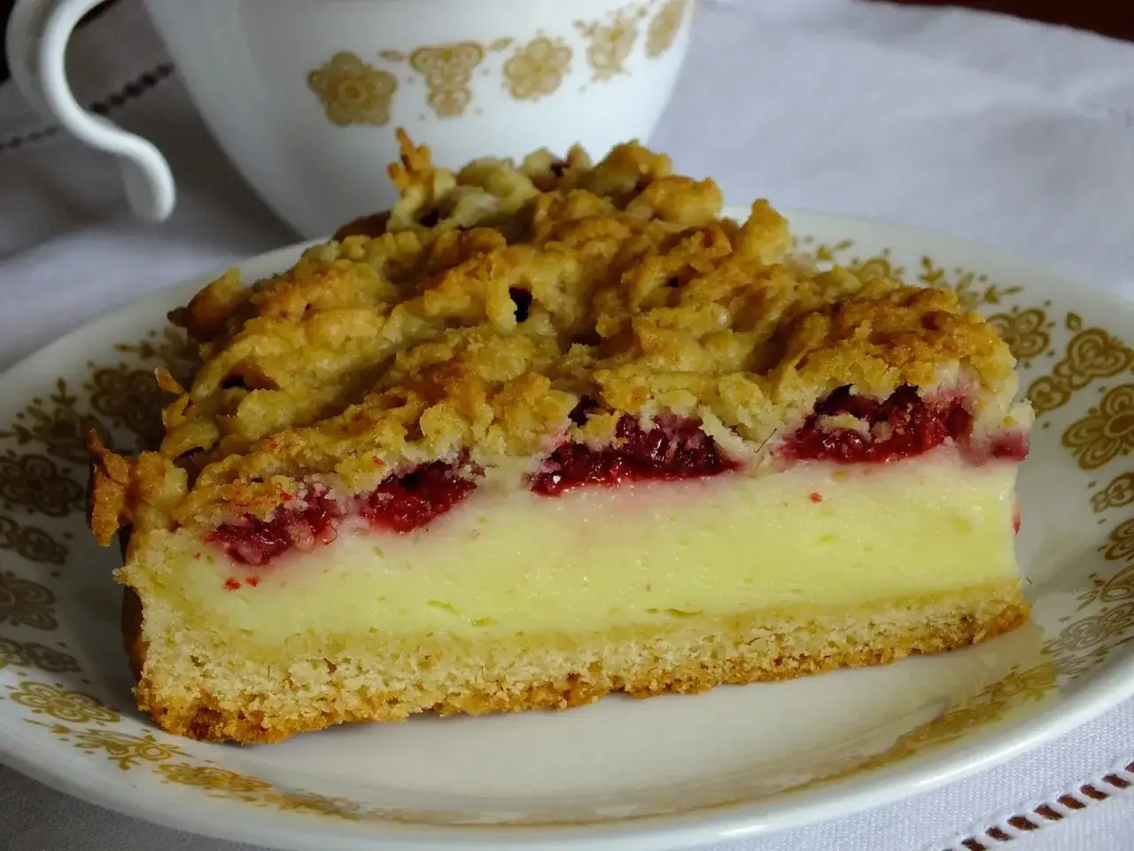 Pyszne ciasto z malinami i budyniem, posypane kruszonką. Idealne na deser z kawą.